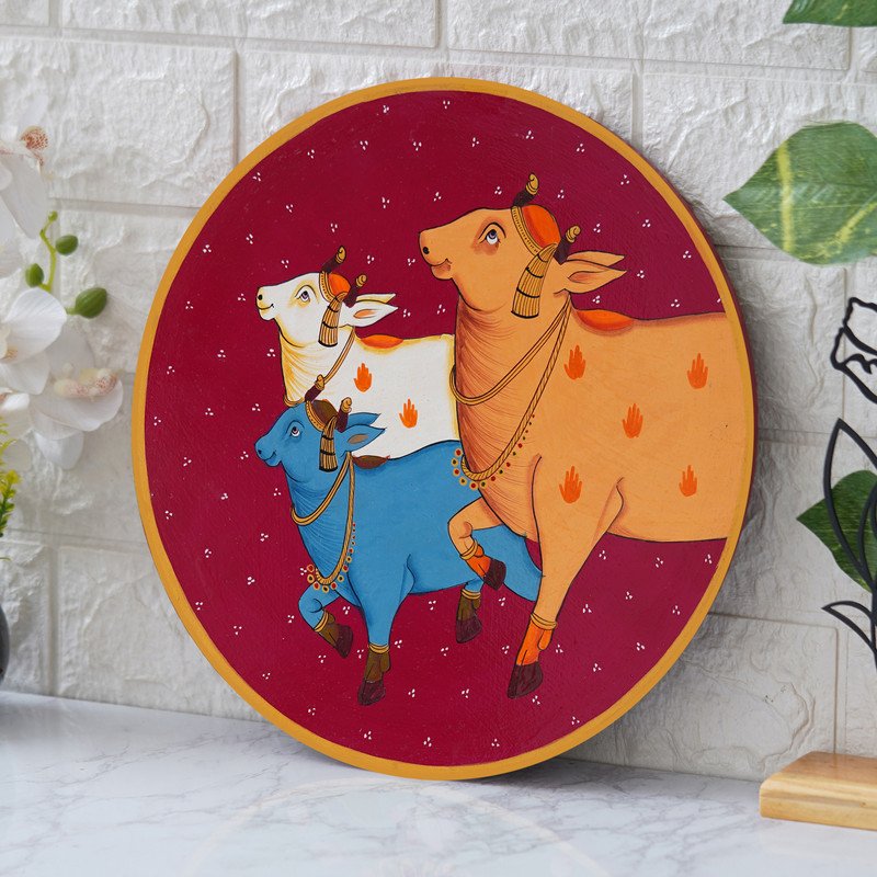 Crafted on a wooden plate, this pichwai portrays three cows in a circular formation.