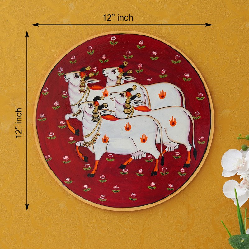 Crafted on a red plate, this pichwai portrays an enchanted encounter between a playful cow and a delicate lotus flower.