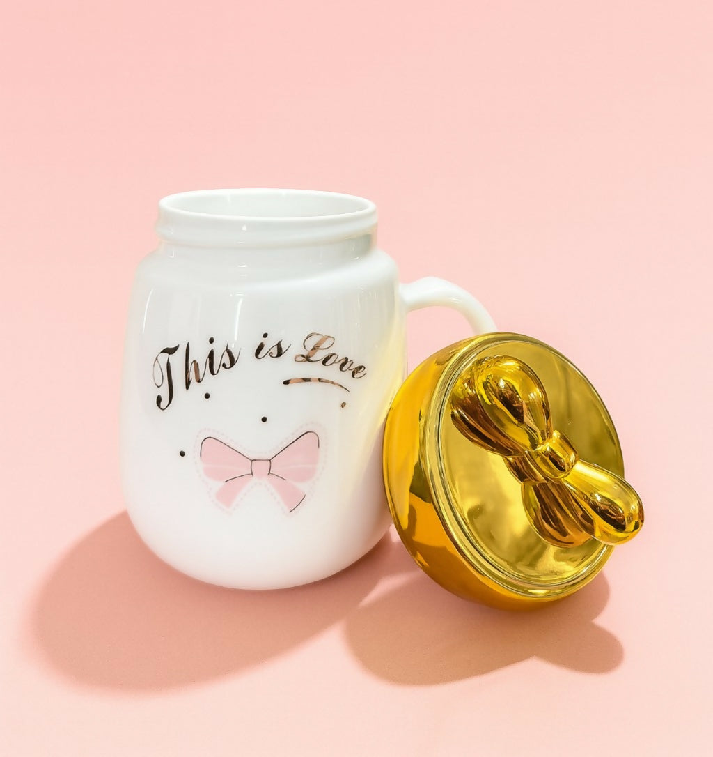 “This is Love” White Ceramic Mug with Golden Heart Lid and Pink Bow Print – Cute Romantic Gift Coffee Cup with Handle for Women, Girls & Couples – Premium Valentine & Anniversary Mug