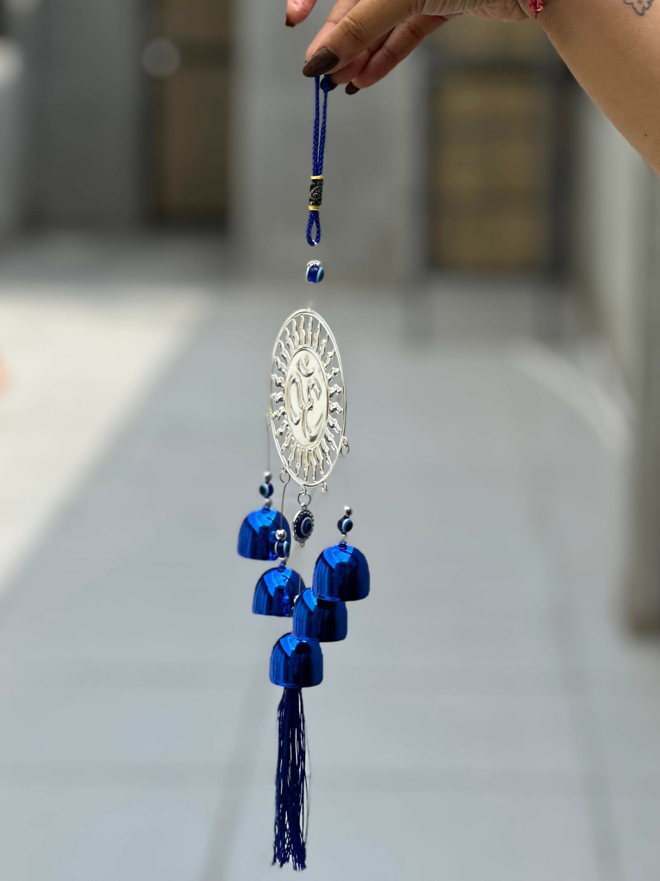 Spiritual Om Wall Hanging with Sun Design and Evil Eye Charms – Blue Metal Decorative Bell Wind Chime with Tassels for Positive Energy, Protection, and Home Vastu – Ideal for Home, Office, Balcony, or Gift Use