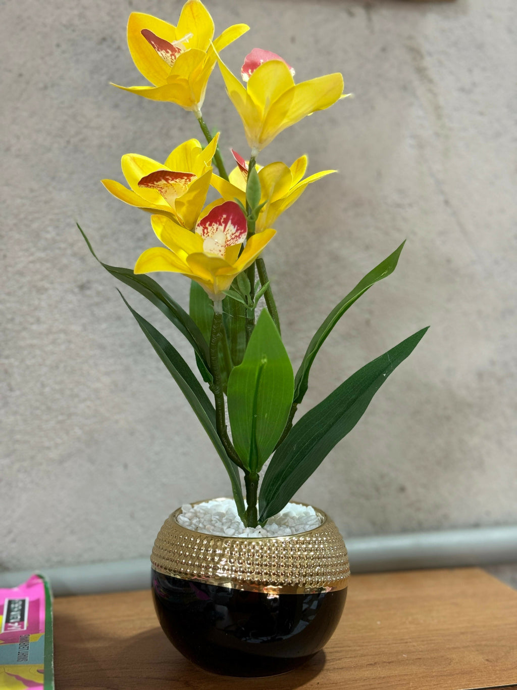 Premium Artificial Yellow Orchid Lily Flower Plant in Glossy Round Pot with Golden Textured Rim – Faux Floral Arrangement with Pebbles for Home, Office & Gifting